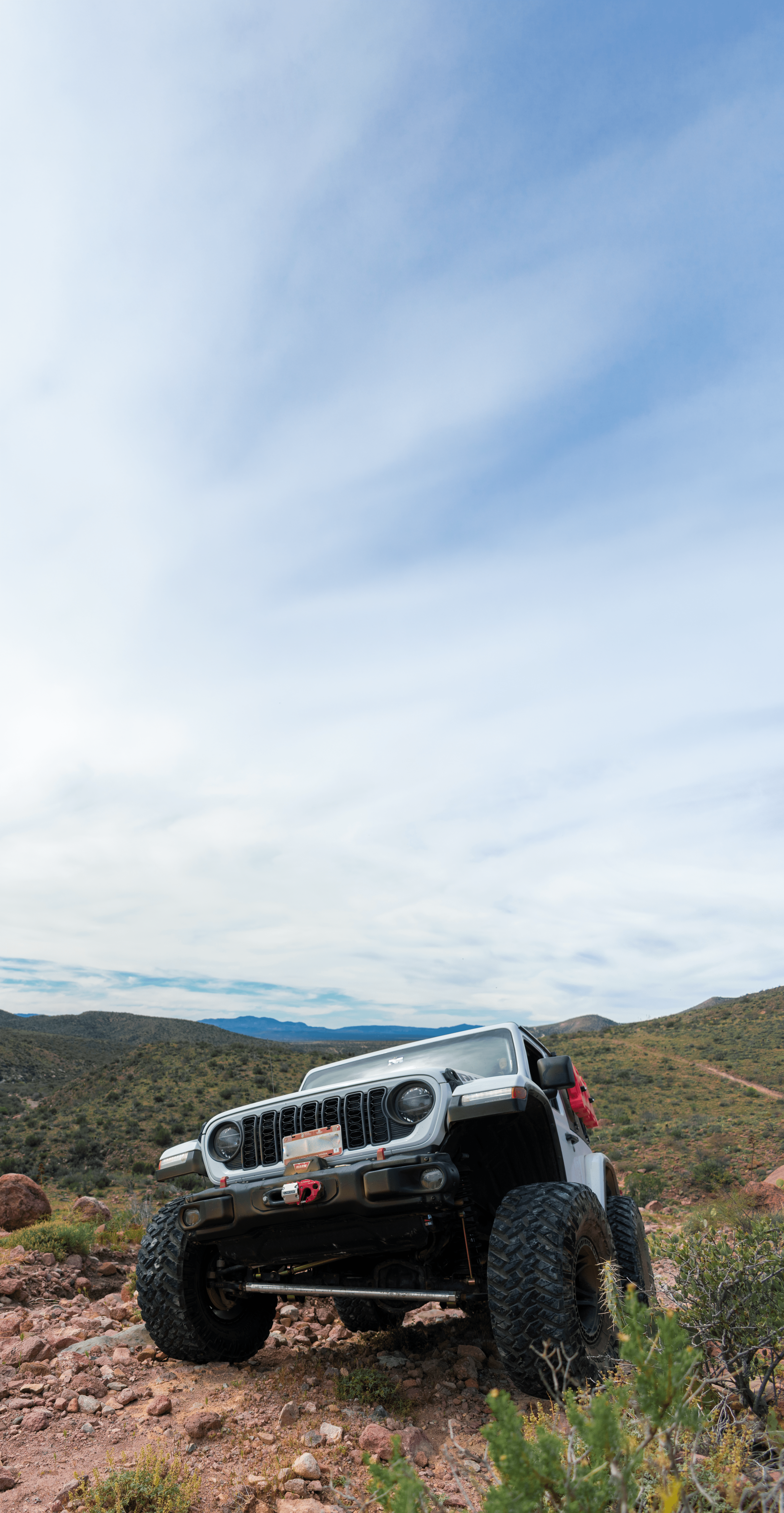 Red Jeep Wrangler in a scenic outdoor setting